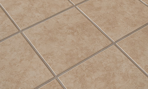 Close-up view of beige ceramic floor tiles arranged in a grid pattern with light-colored grout lines between each tile.