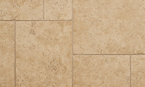 Beige stone tiles with a natural, slightly speckled texture arranged in a staggered pattern, showing subtle color variations and grout lines.